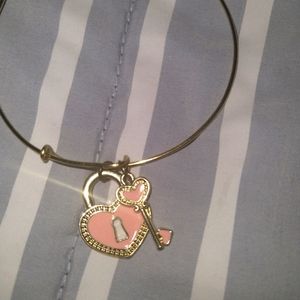 Gold bracelet with pink key charm